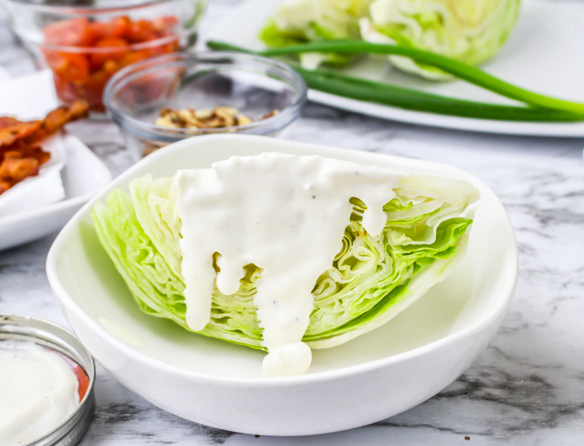 wedge of lettuce drizzled with white dressing