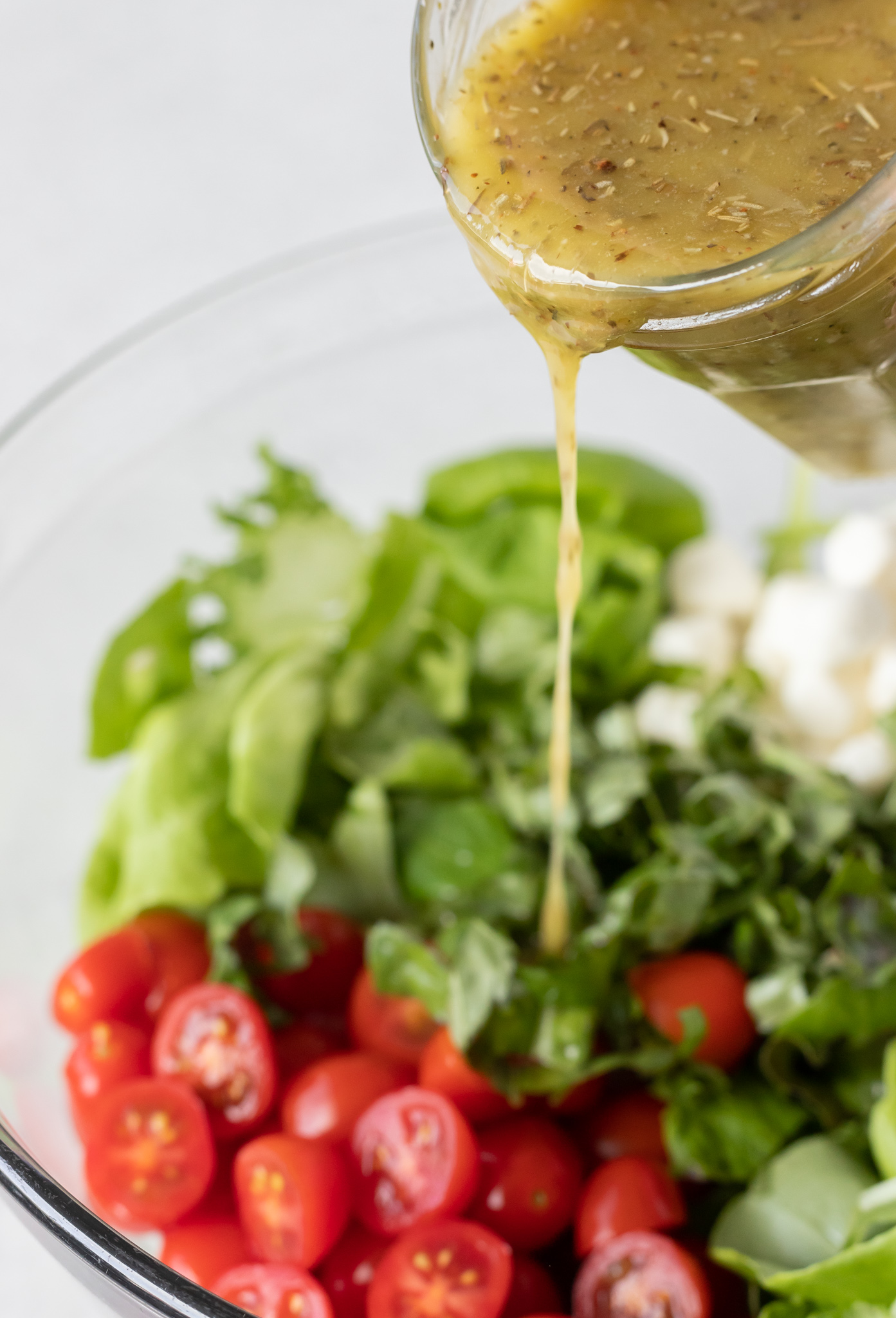 dressing being poured over salad