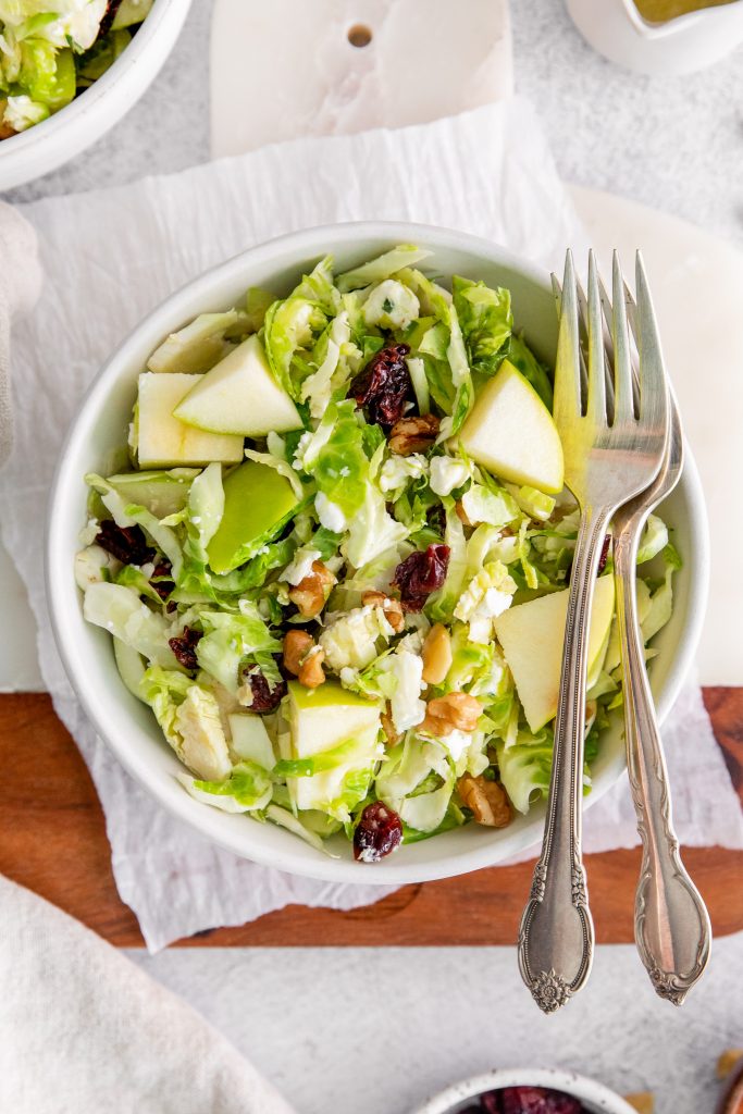 prepared Brussels sprouts salad in bowl with forks