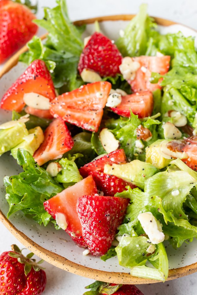 fresh red strawberries in green salad