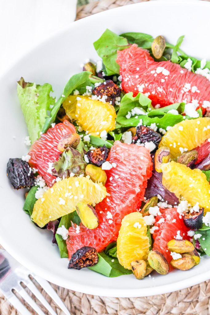 citrus and greens salad in white bowl
